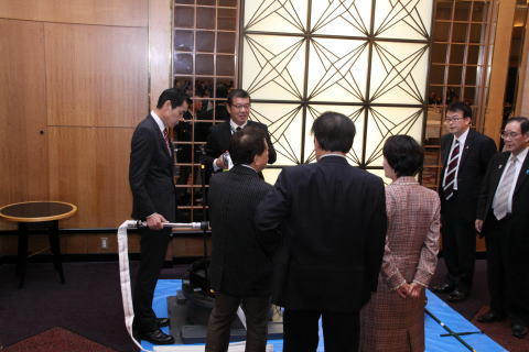 画像：東京消防庁・水道局職員から排水栓の説明を受ける各首脳の様子