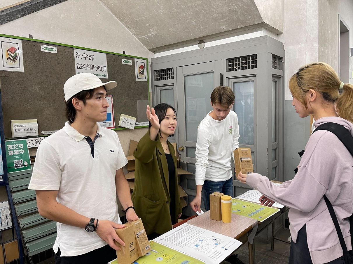 写真：塾生会議「ウォーターサーバープロジェクト」：マイボトルを配布する学生